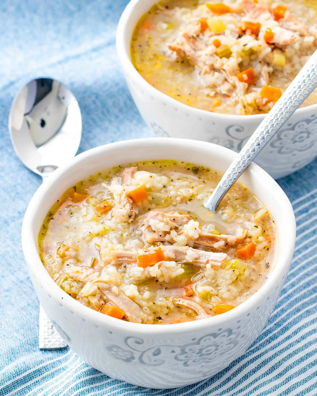 a bowl of freshly made chicken and rice soup with a spoon in it.