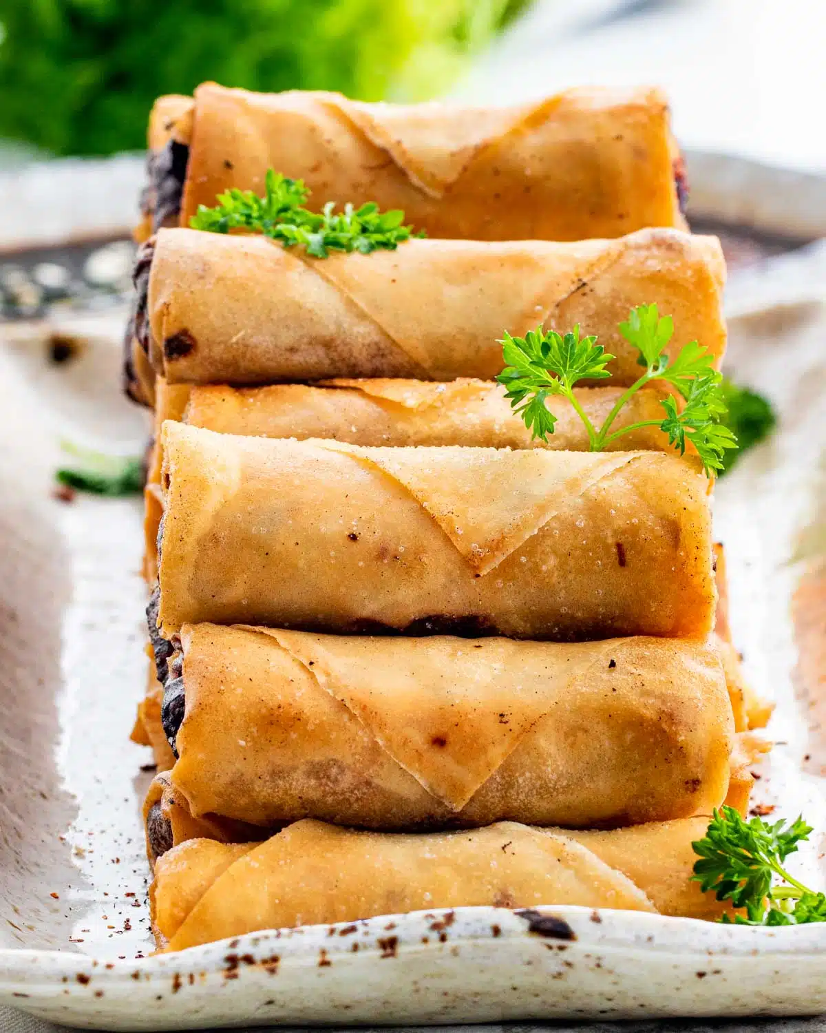 a bunch of freshly made spring rolls on a serving platter.