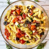 overhead shot of italian pasta salad in a glass bowl.