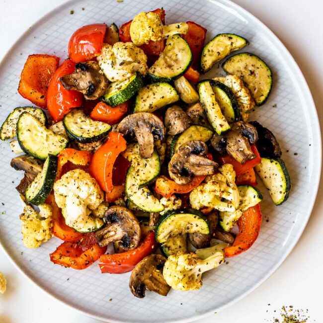roasted vegetables made in the air fryer on a white plate.