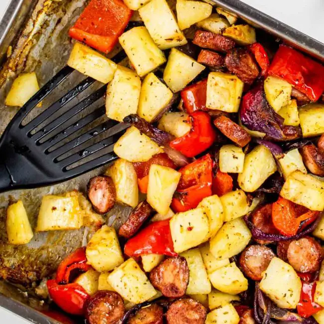 roasted sausage and potatoes in a roasting pan.