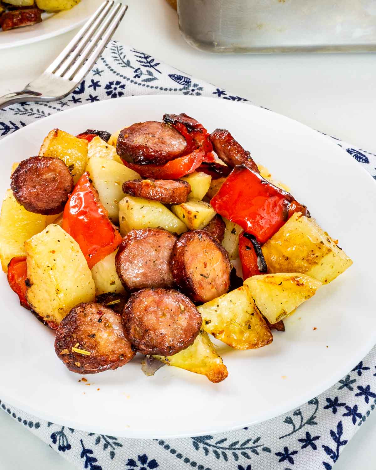 roasted sausage and potatoes on a white plate.