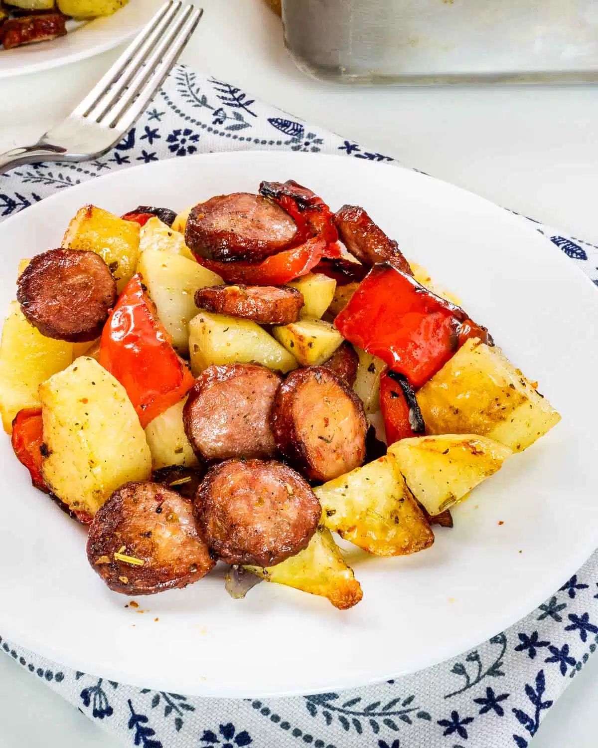 roasted sausage and potatoes on a white plate.