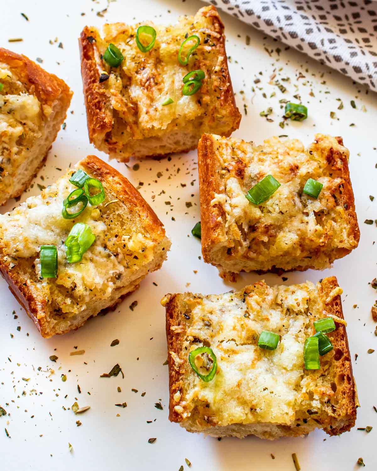 a few pieces of garlic bread garnished with some green onions.
