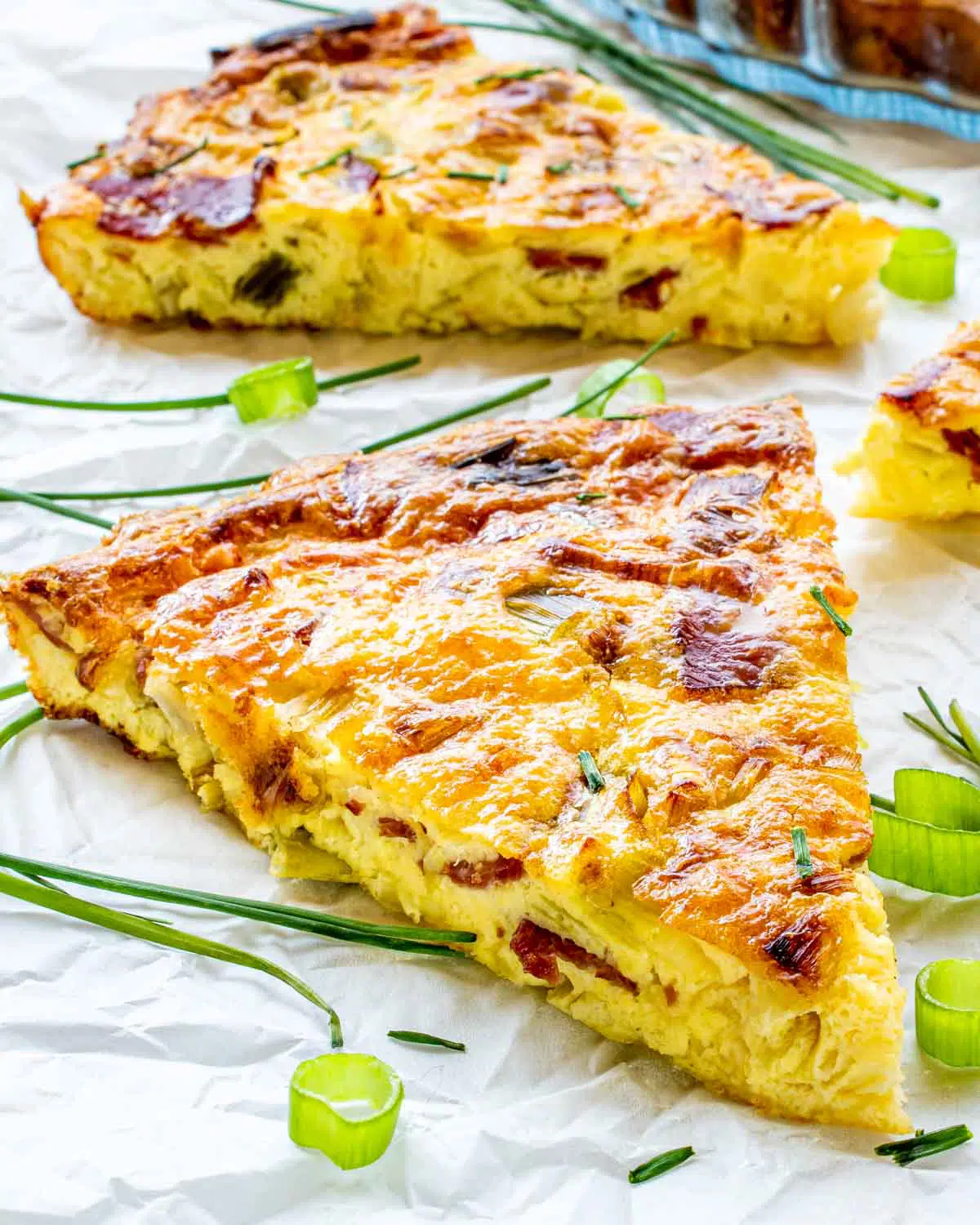 a slice of crustless quiche garnished with green onions.