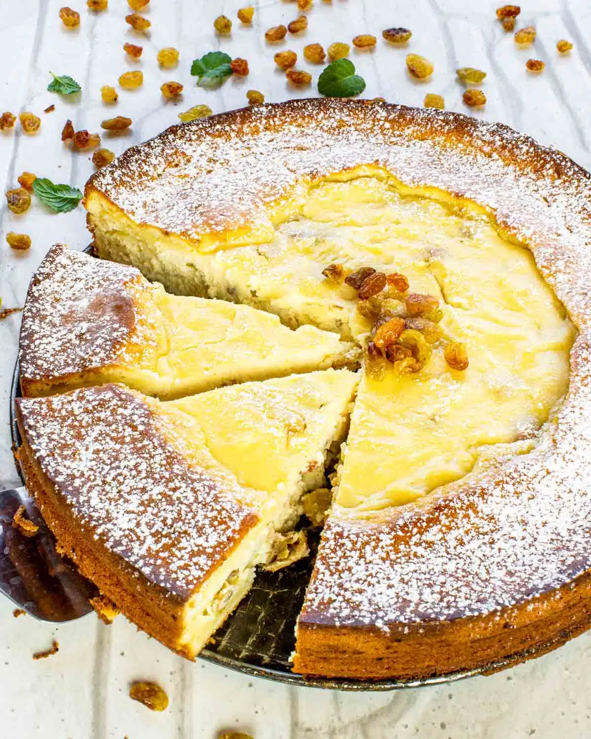 freshly baked ricotta cheesecake with 2 slices cut out.