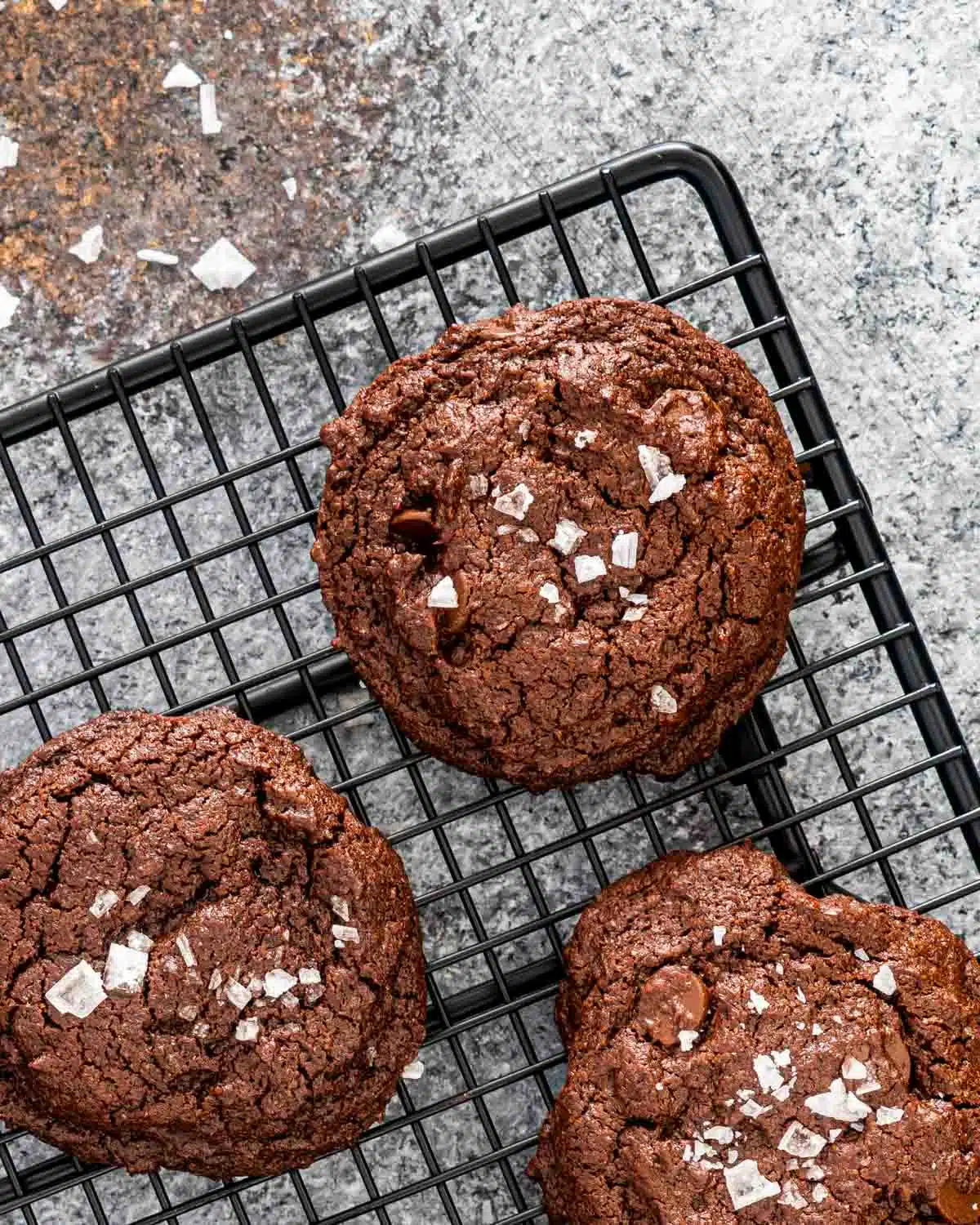chocolate brownie cookies cooling off on a black cooling rack.