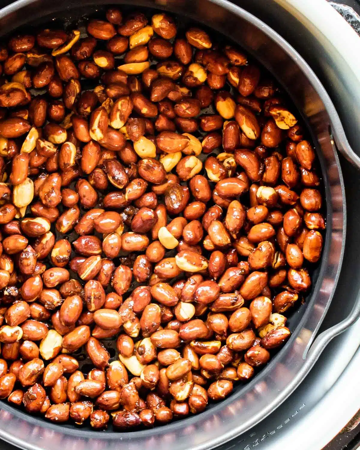 roasted peanuts in an air fryer basket.