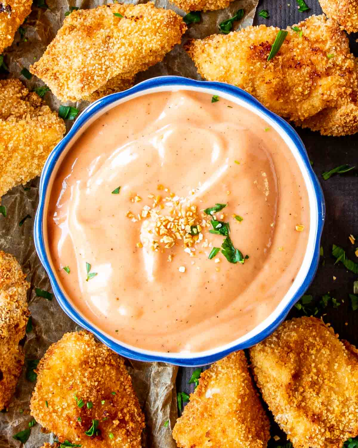 fry sauce in a bowl surrounded by some chicken nuggets.