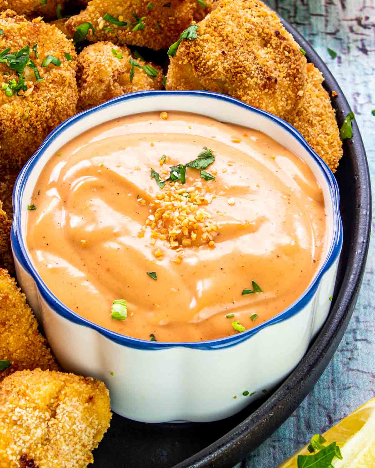 fry sauce in a bowl surrounded by some chicken nuggets.