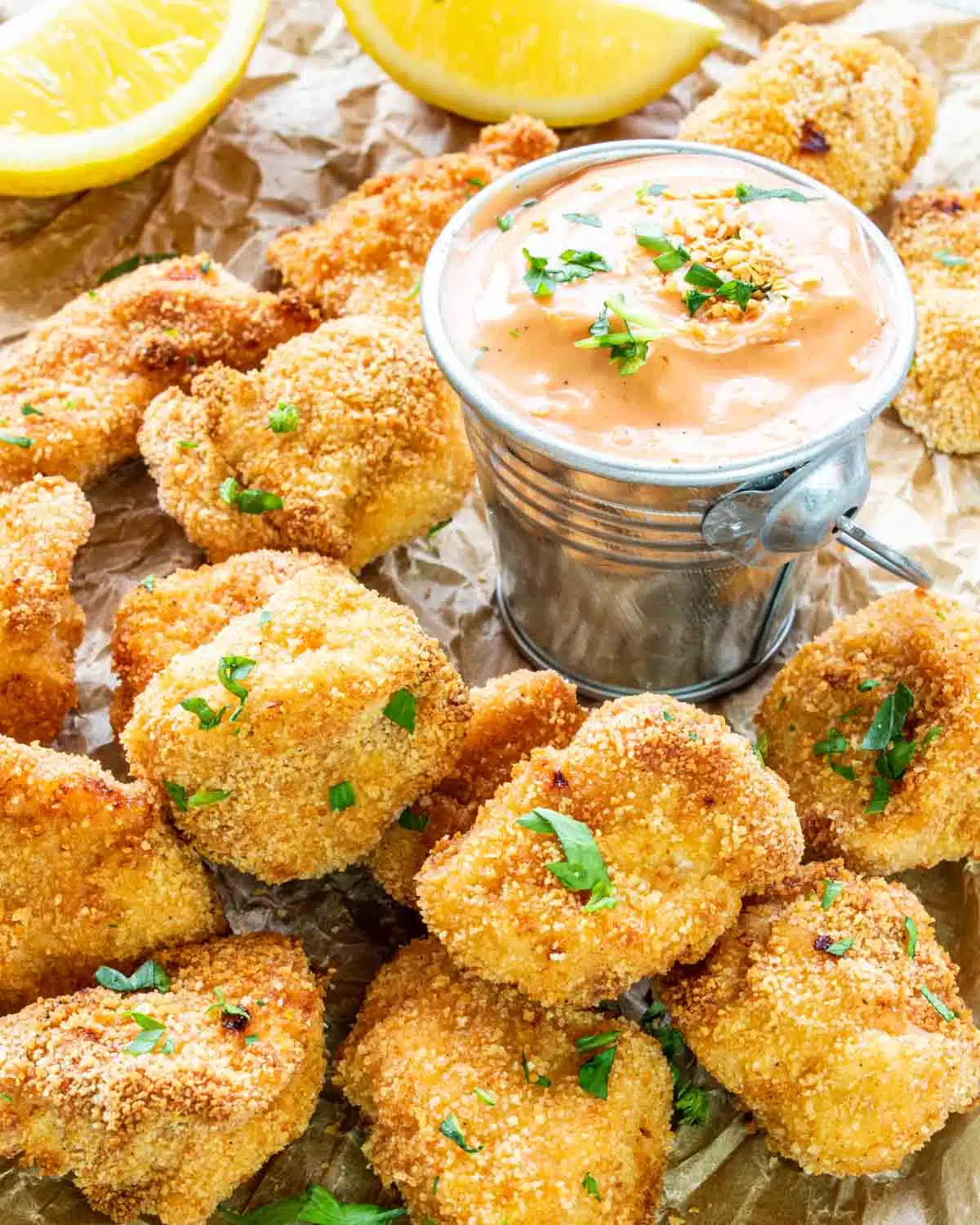 air fryer chicken nuggets with fry sauce garnished with parsley.