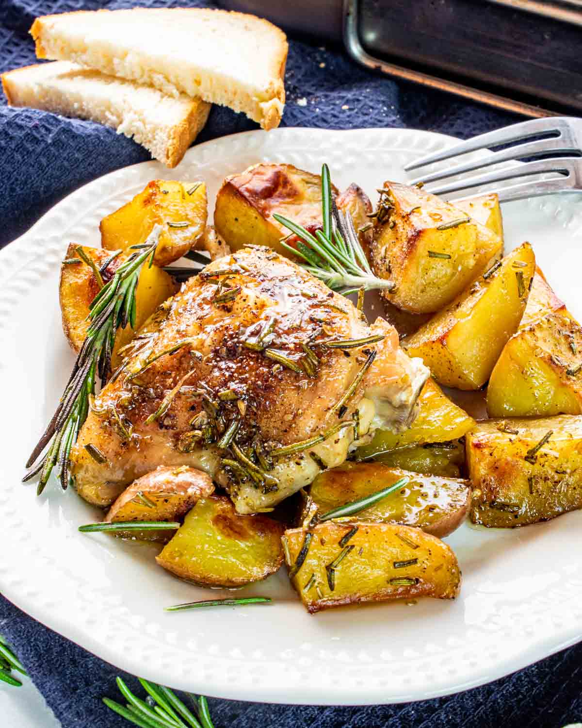 rosemary chicken and potatoes on a white plate.