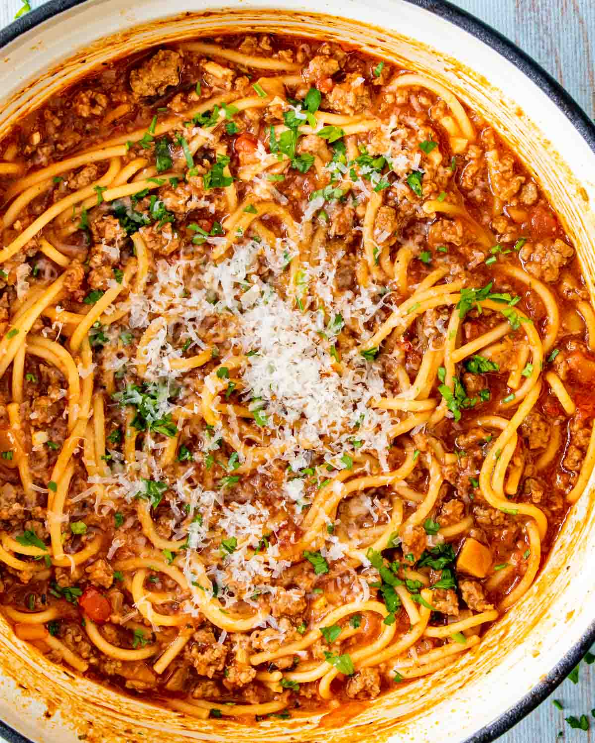 one pot spaghetti garnished with parmesan cheese in a dutch oven.