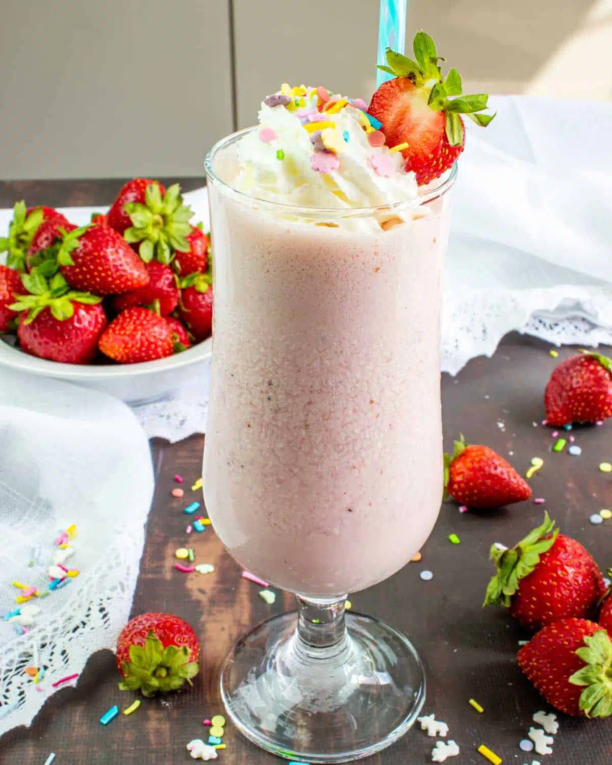 strawberry milkshake topped with whipped cream and sprinkles.