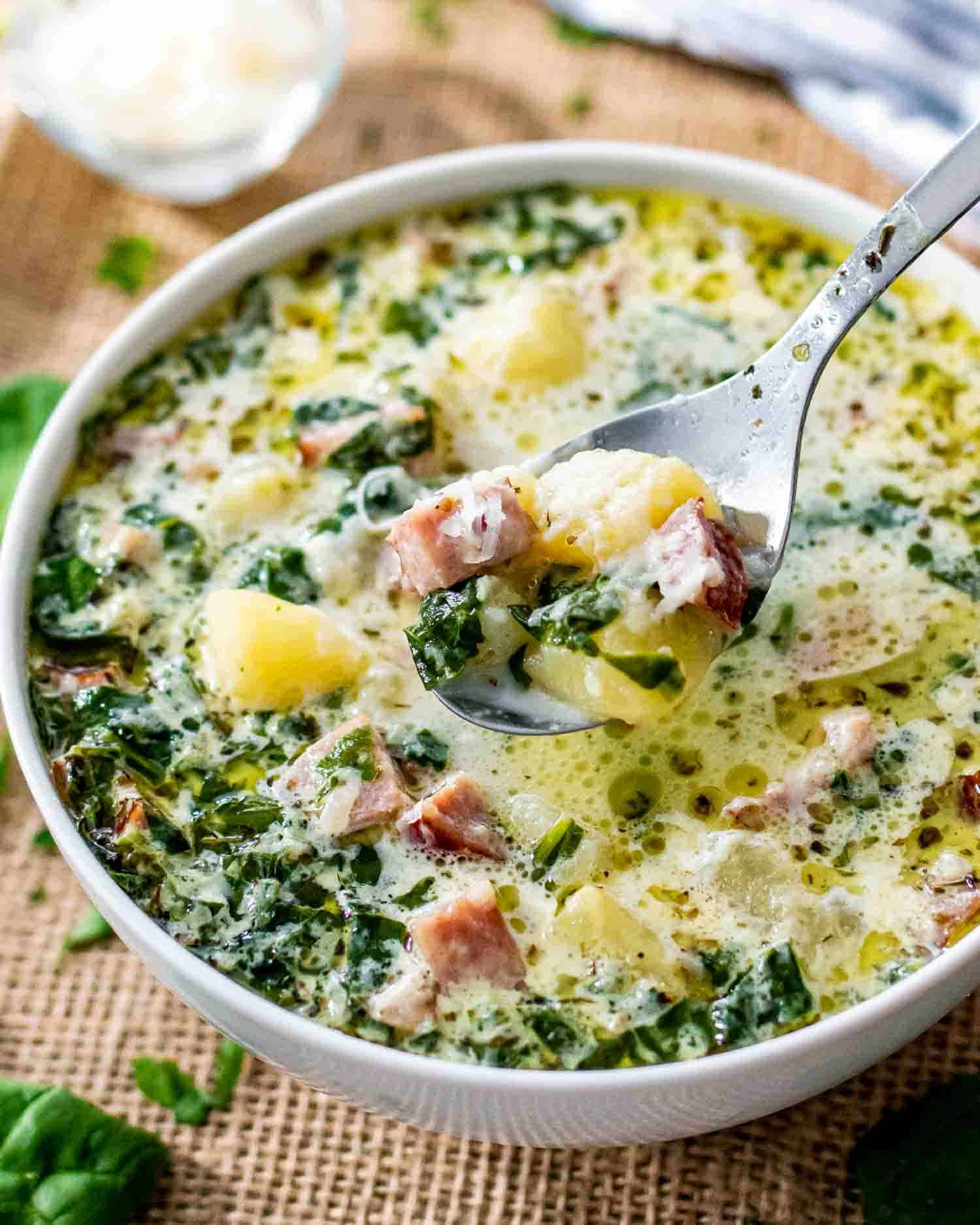 creamy potato sausage soup in a bowl sprinkled with parmesan cheese.