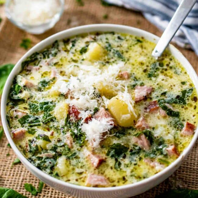 creamy potato sausage soup in a bowl sprinkled with parmesan cheese.