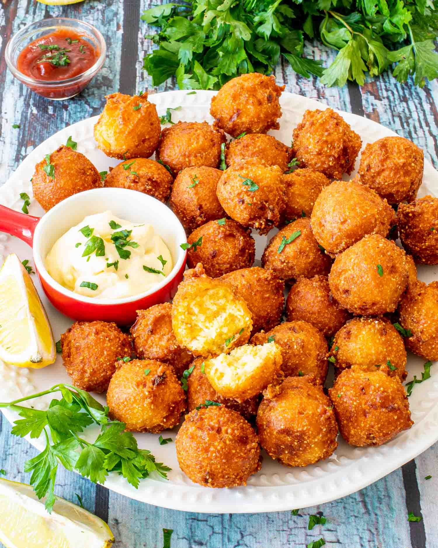 hush puppies on a plate with dipping sauce.