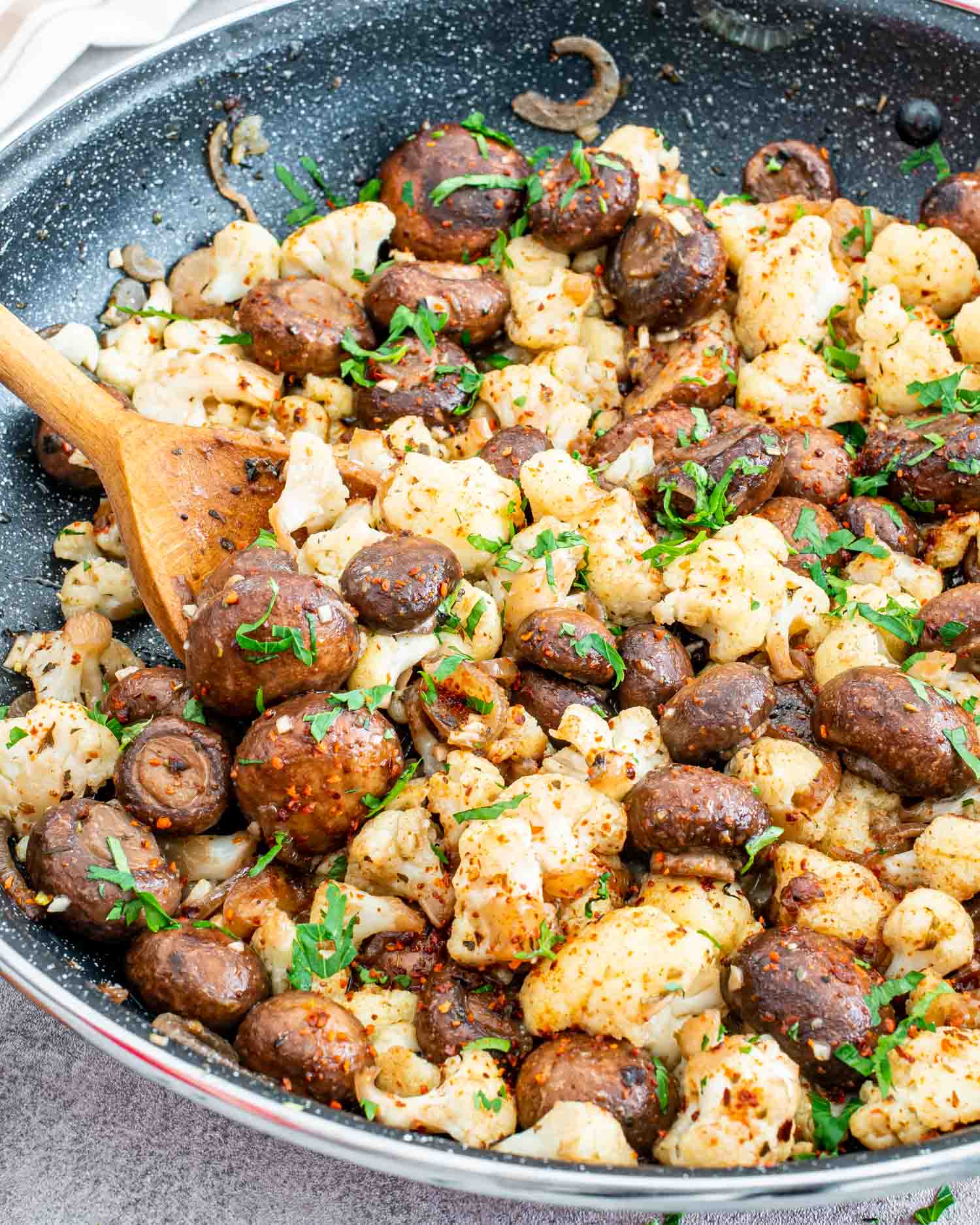 a side dish of mushrooms and cauliflower in a skillet.