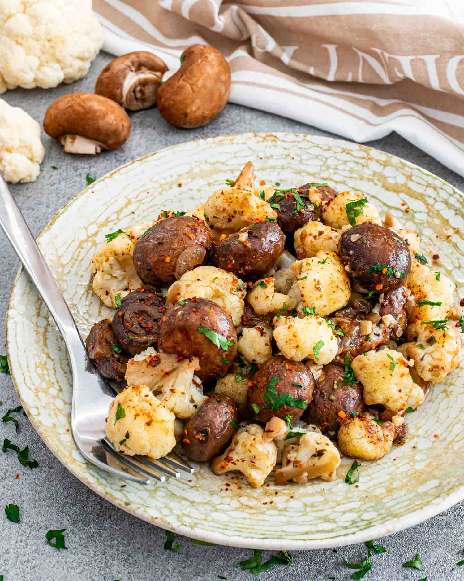 a beautiful side dish of mushrooms and cauliflower on a plate.