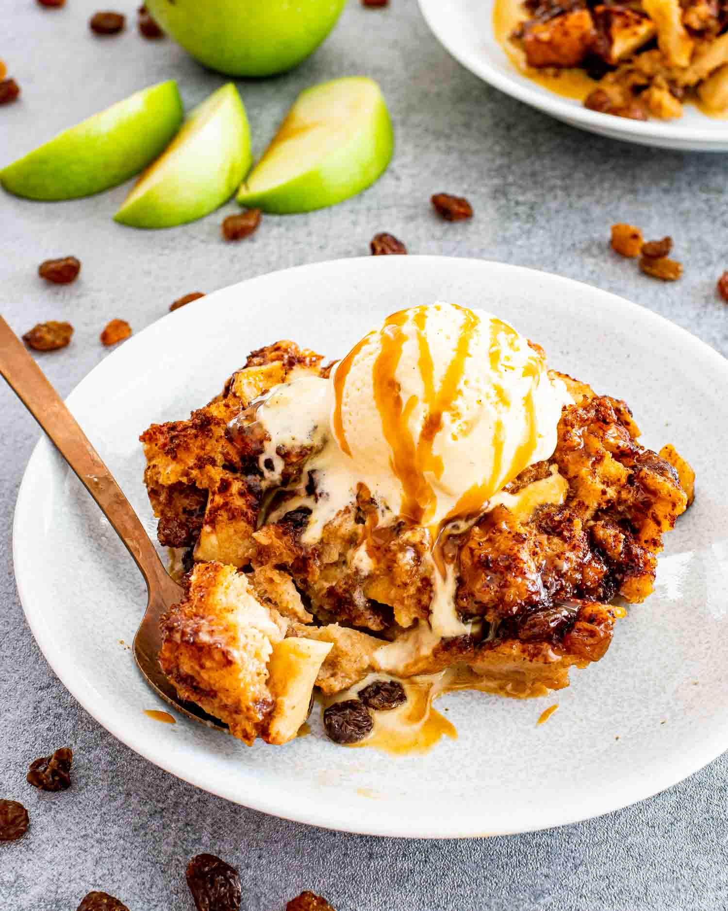 a serving of apple pie bread pudding on a white plate.
