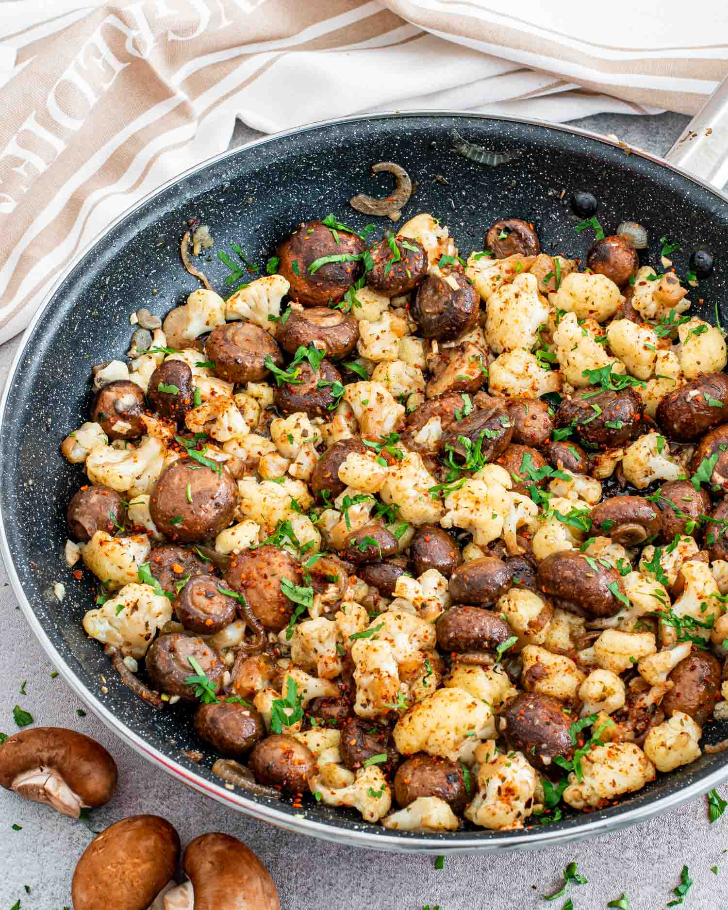 a side dish of mushrooms and cauliflower in a skillet.