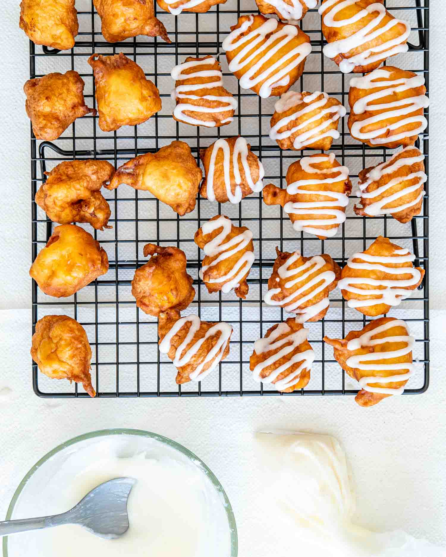 glazed peach fritters on a cooling rack.