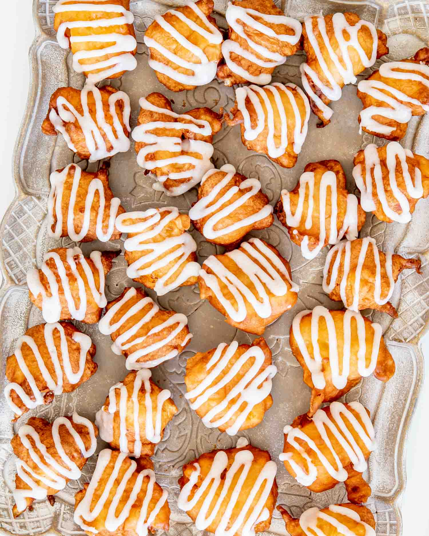 glazed peach fritters on a serving platter.