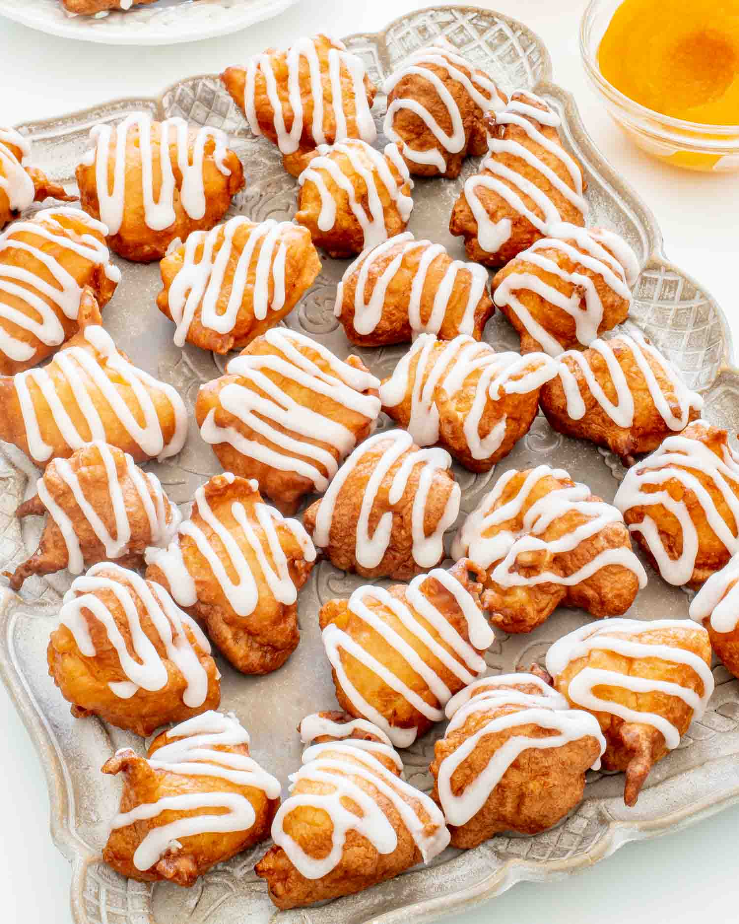 glazed peach fritters on a serving platter.