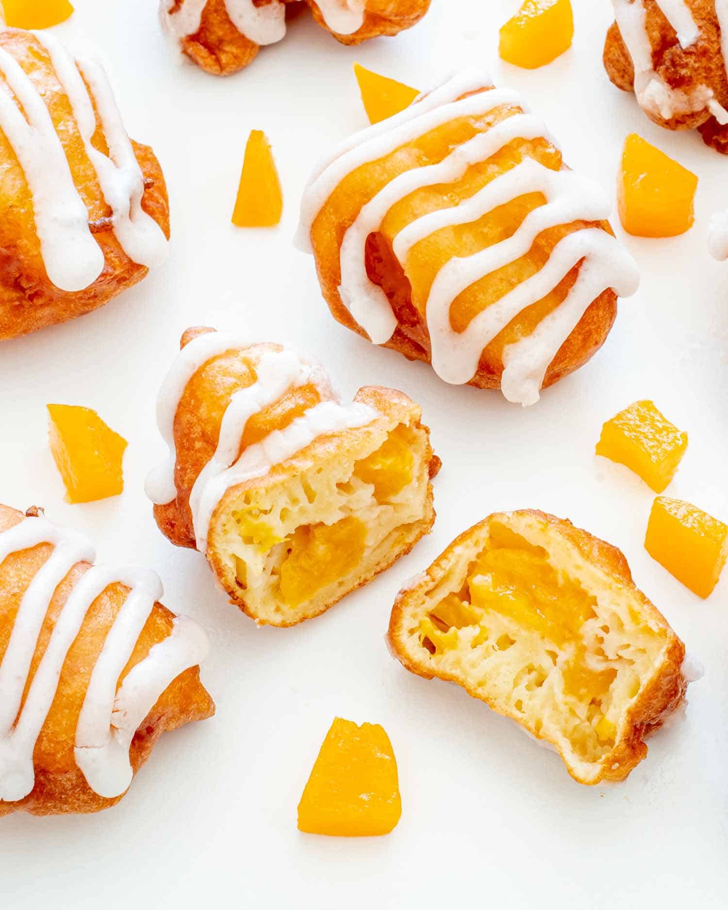 a few peach fritters with one cut in half.