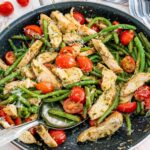 freshly made pesto chicken and veggies in a skillet.