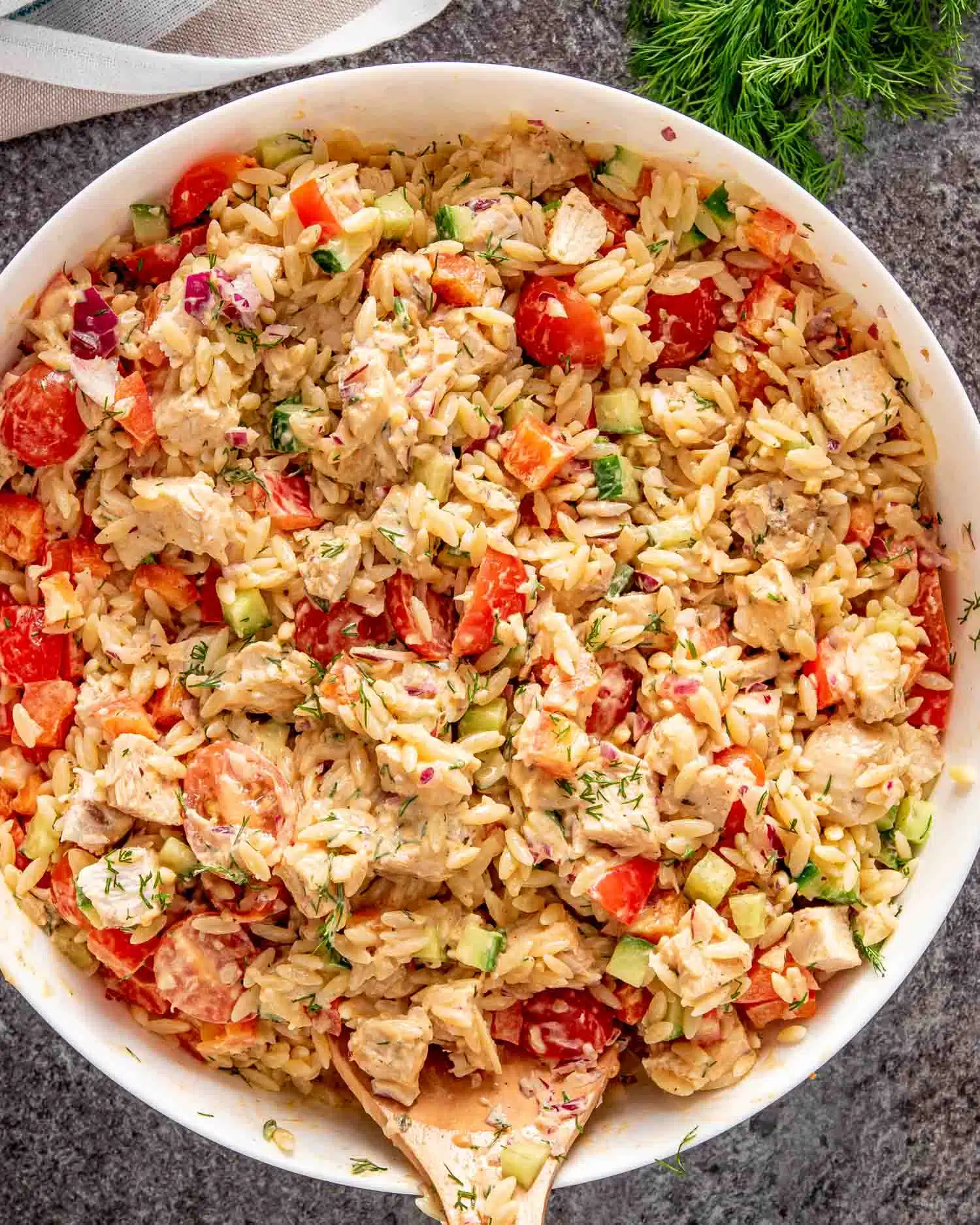 freshly made chicken orzo pasta salad in a white bowl.