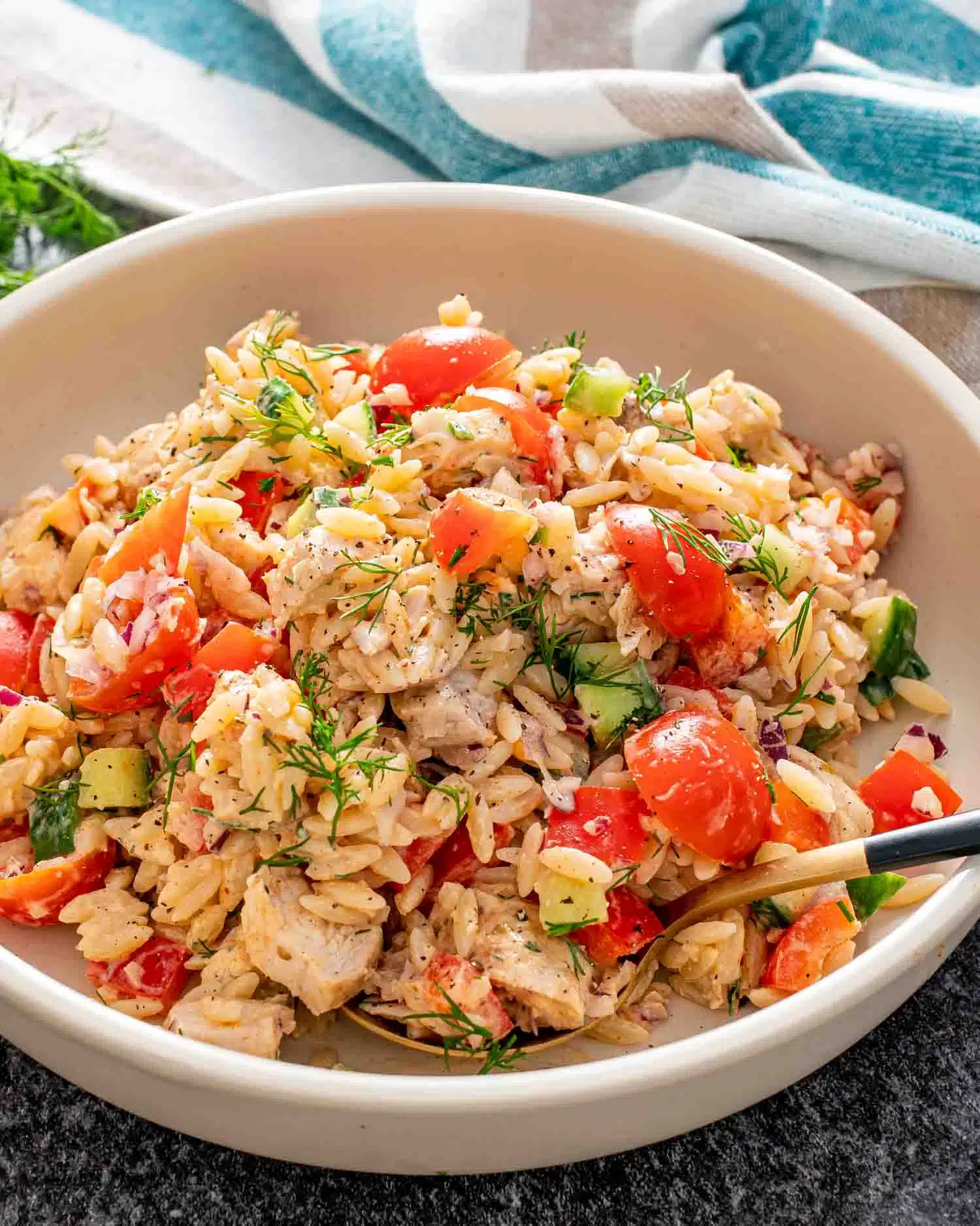 freshly made chicken orzo pasta salad in a white bowl.