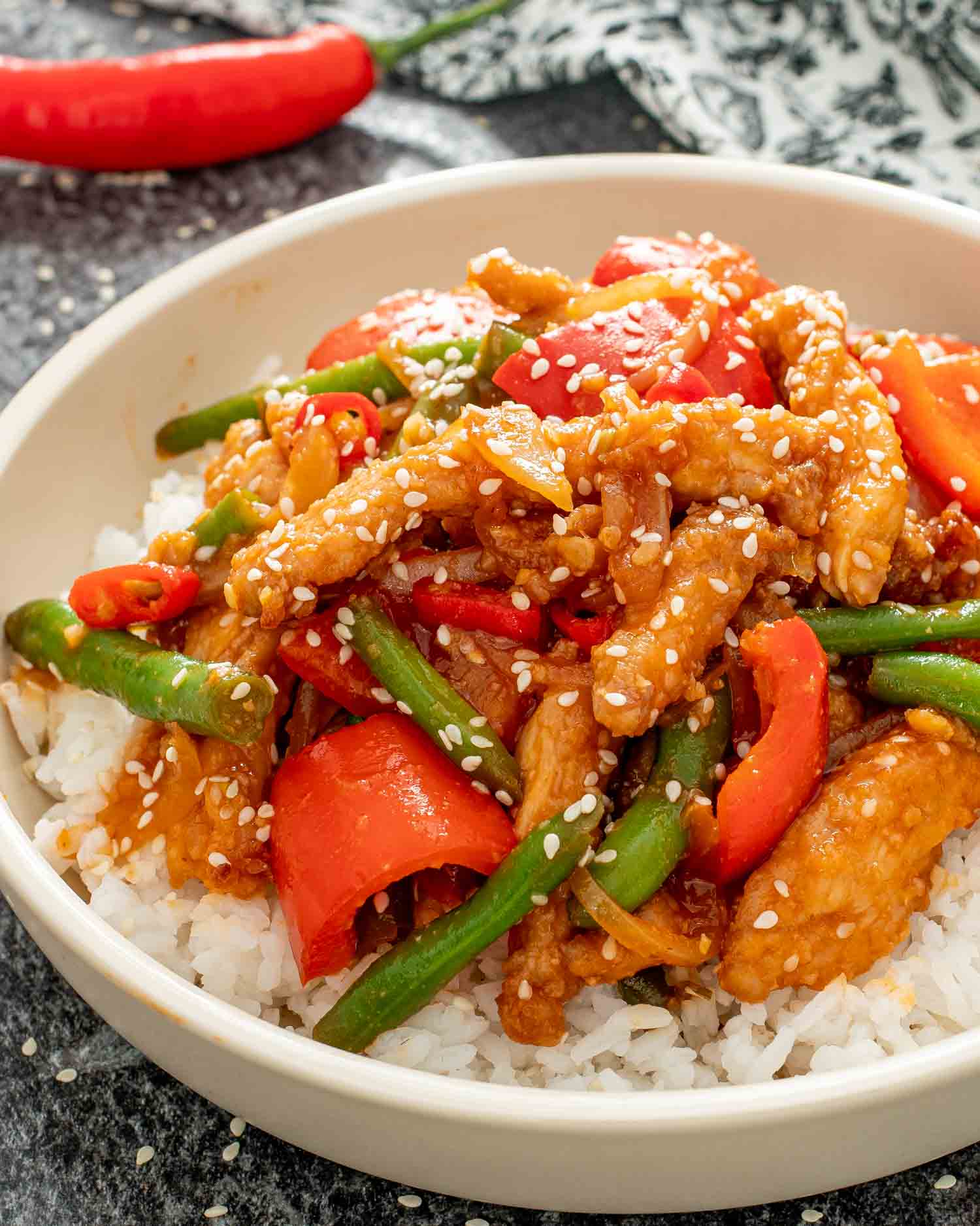 crispy honey chili chicken with rice in a beige bowl.