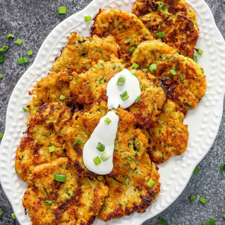 freshly made vegetable fritters on a white serving platter.