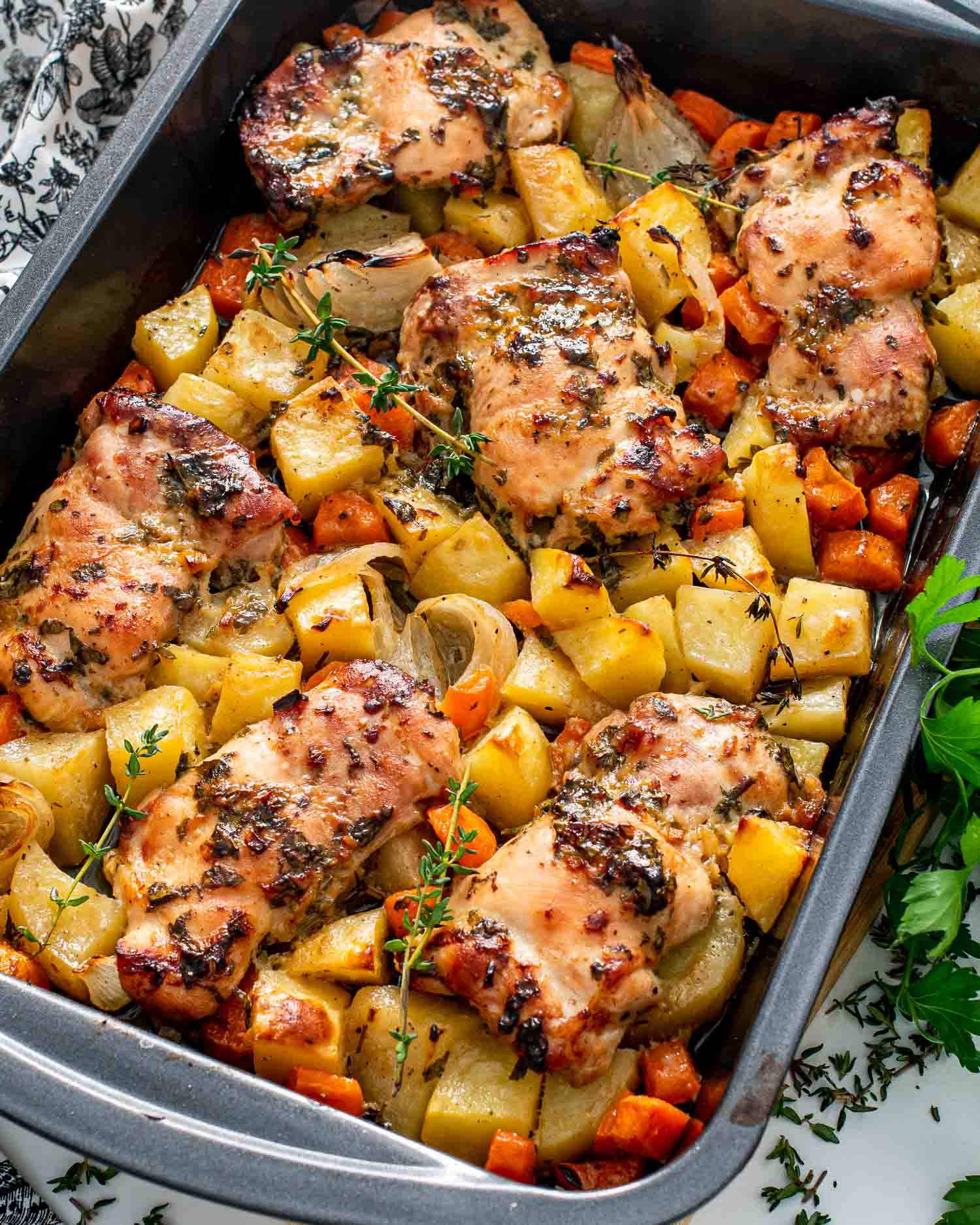 fresh out of the oven baked honey mustard chicken with potatoes in a baking pan.