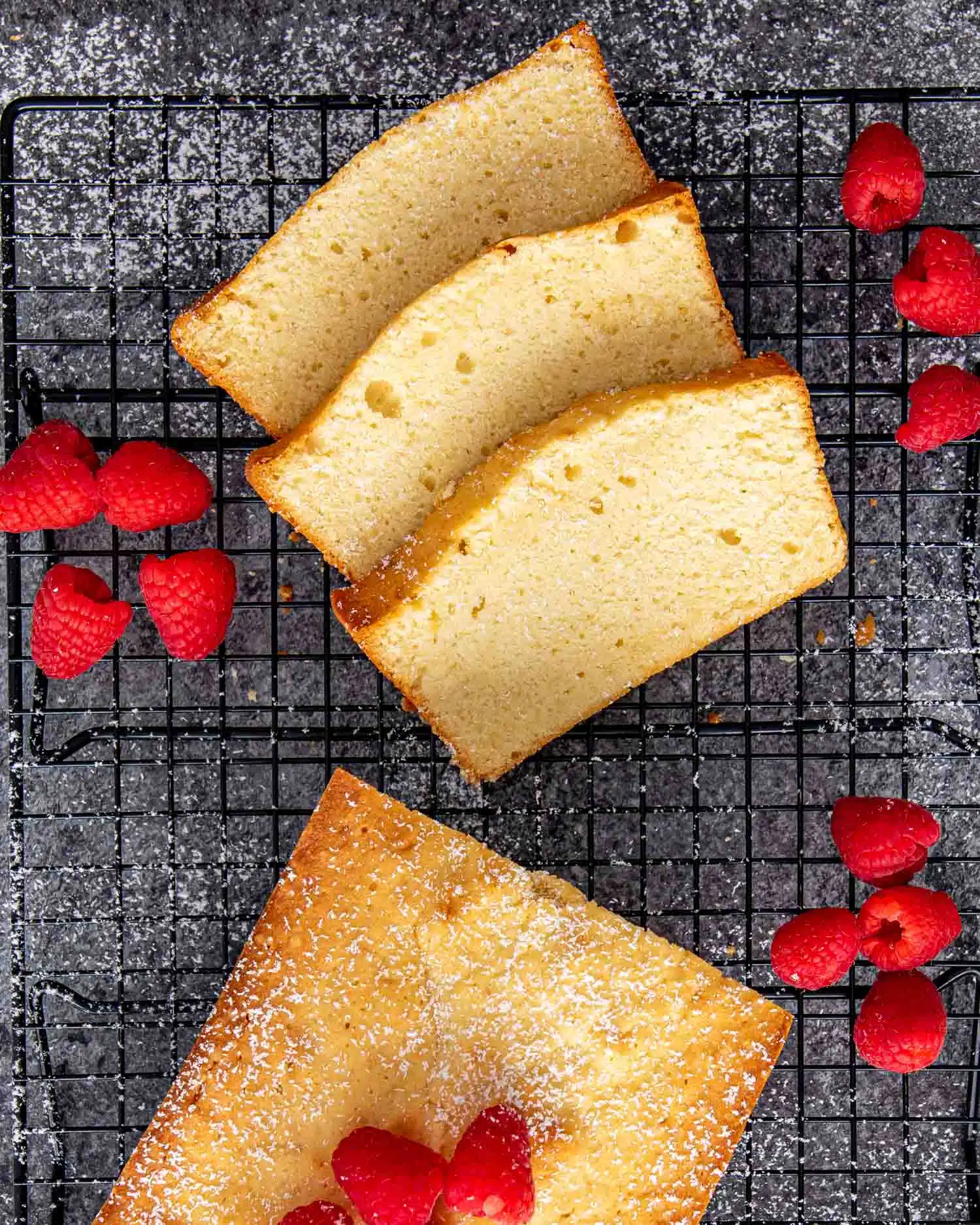 a condensed milk pound cake with a few slices cut out on a black cooling rack.