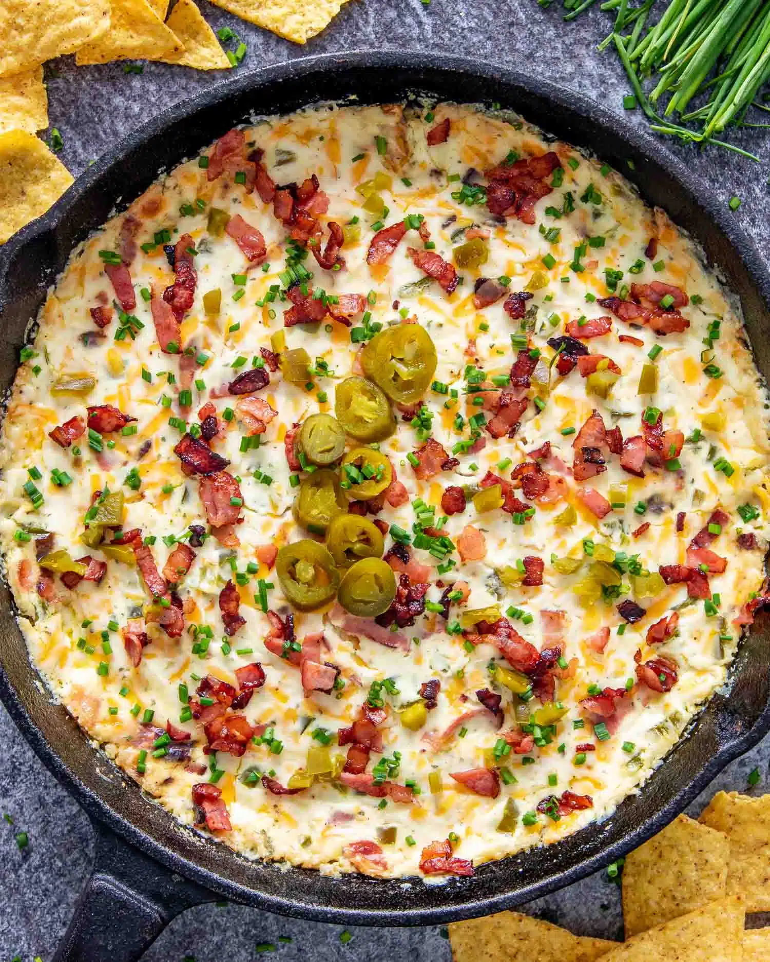 jalapeno popper dip in a black cast iron skillet fresh out of the oven.