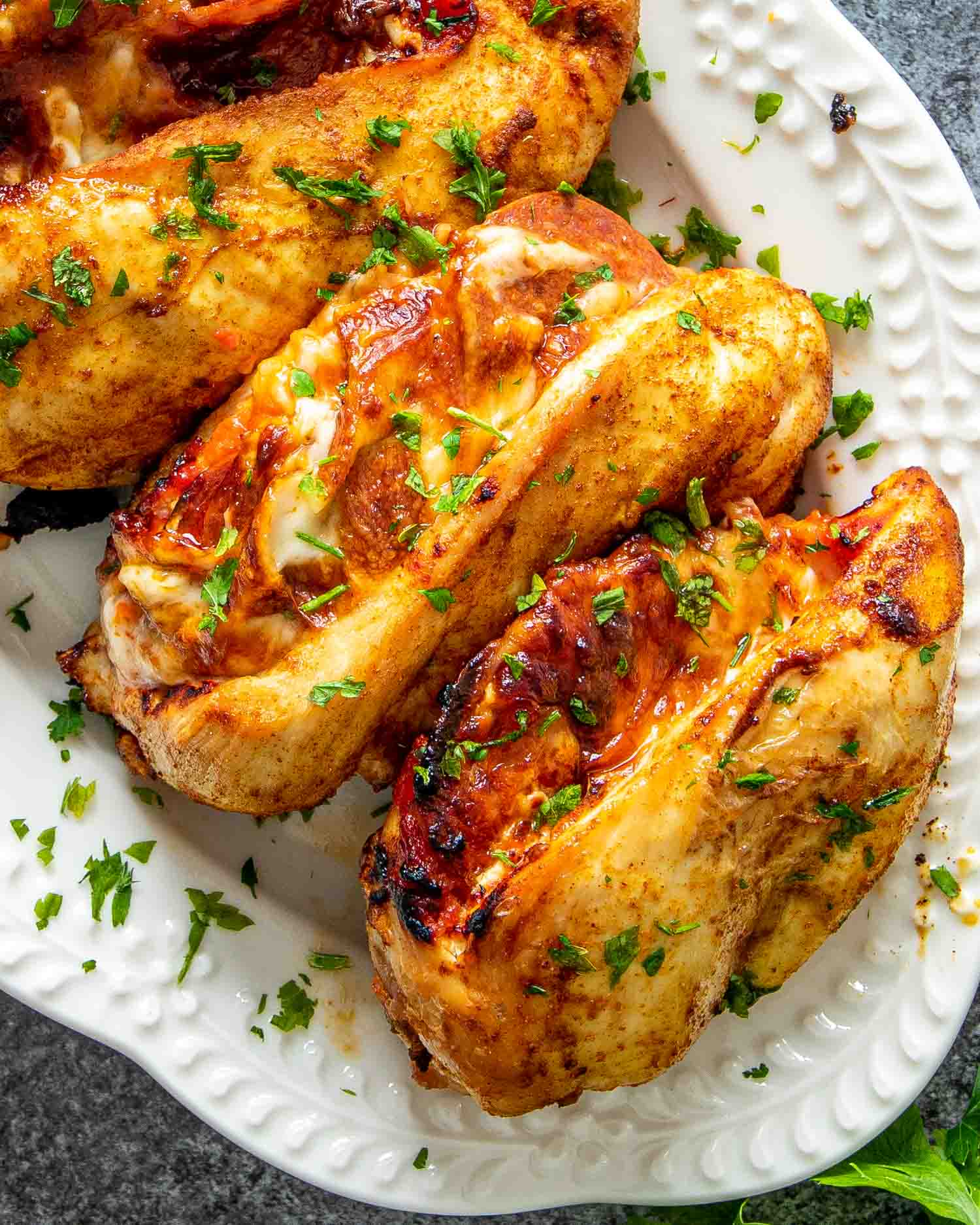 pizza stuffed chicken breasts on a white serving platter.