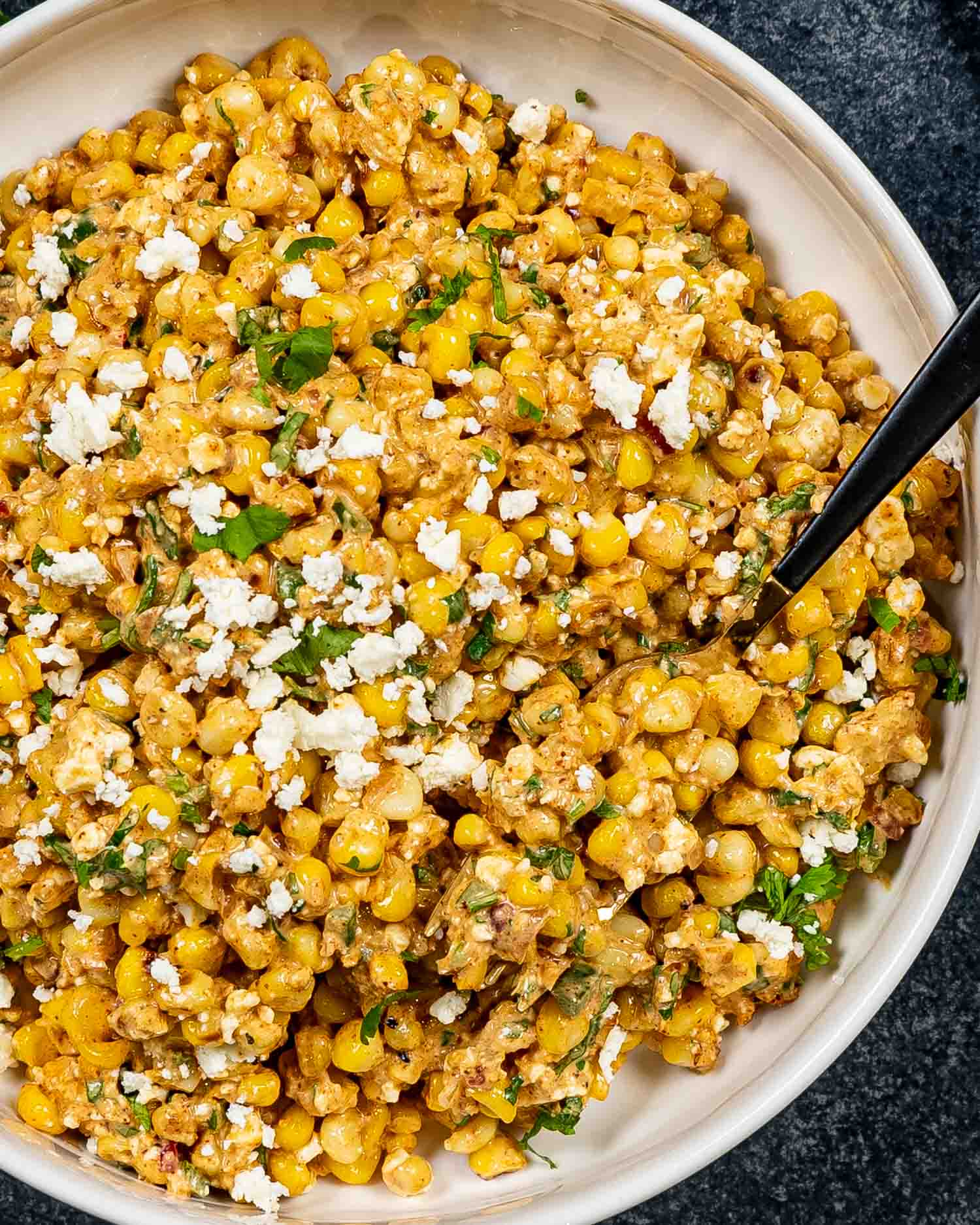 freshly made (mexican street corn salad in a white bowl.