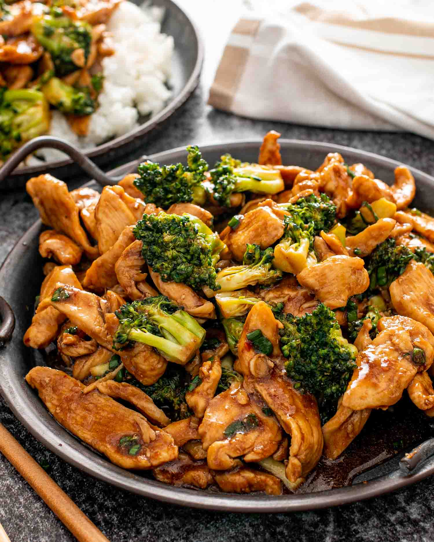 freshly made asian style chicken and broccoli on a metal plate.