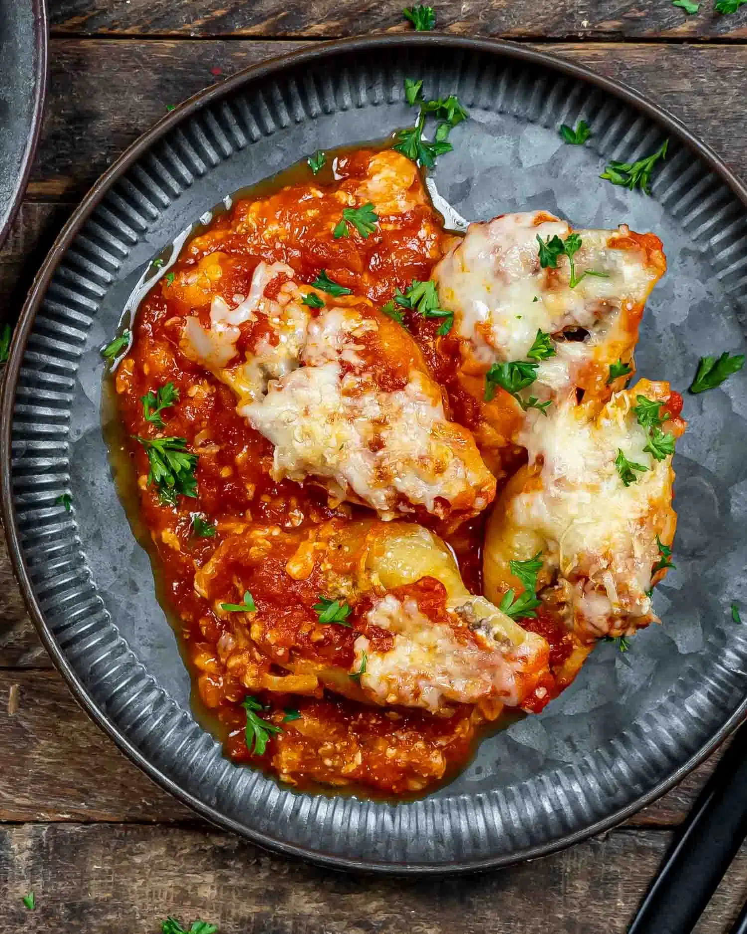 a serving of stuffed shells on a metal plate.