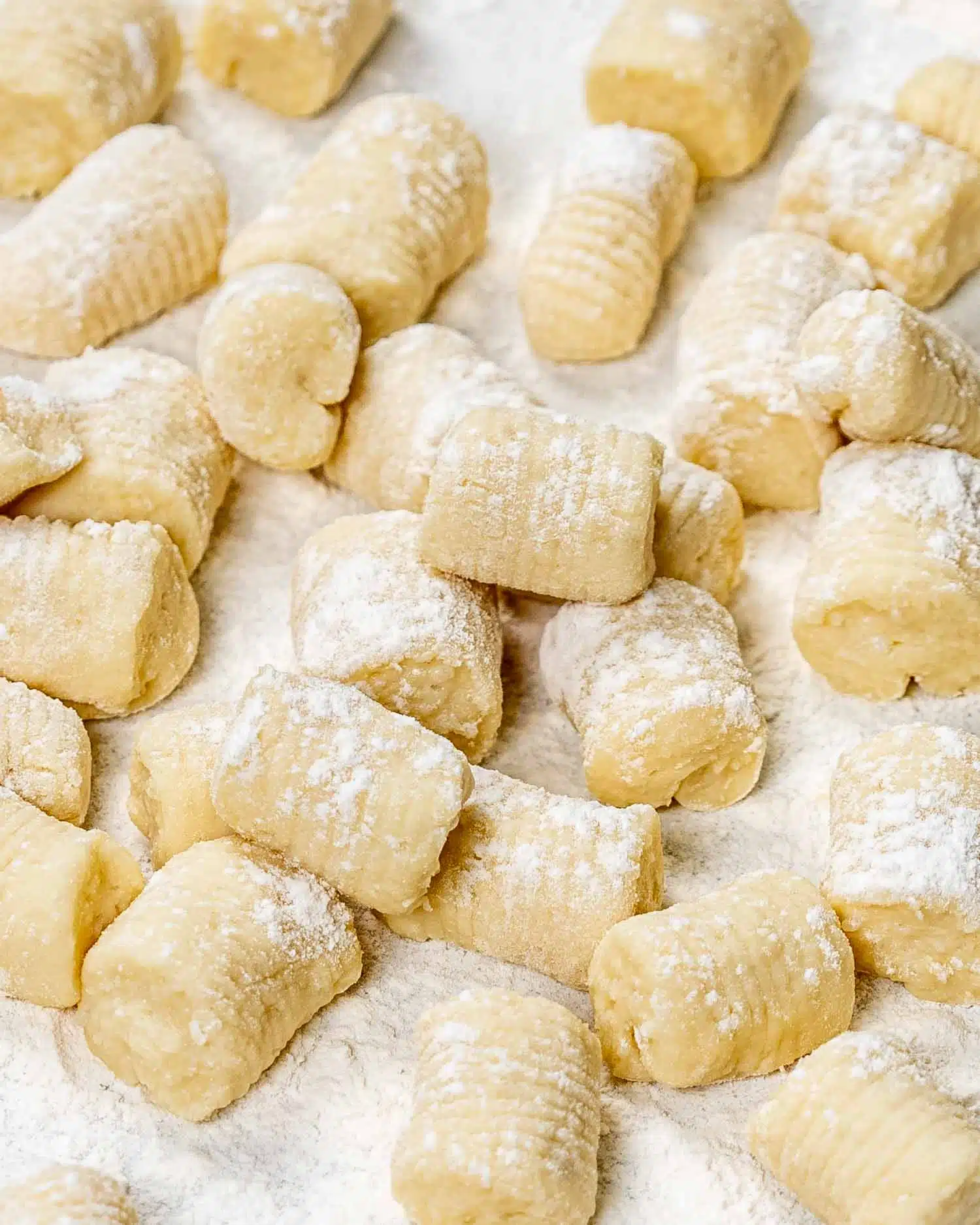 freshly made gnocchi coated with flour on a counter.