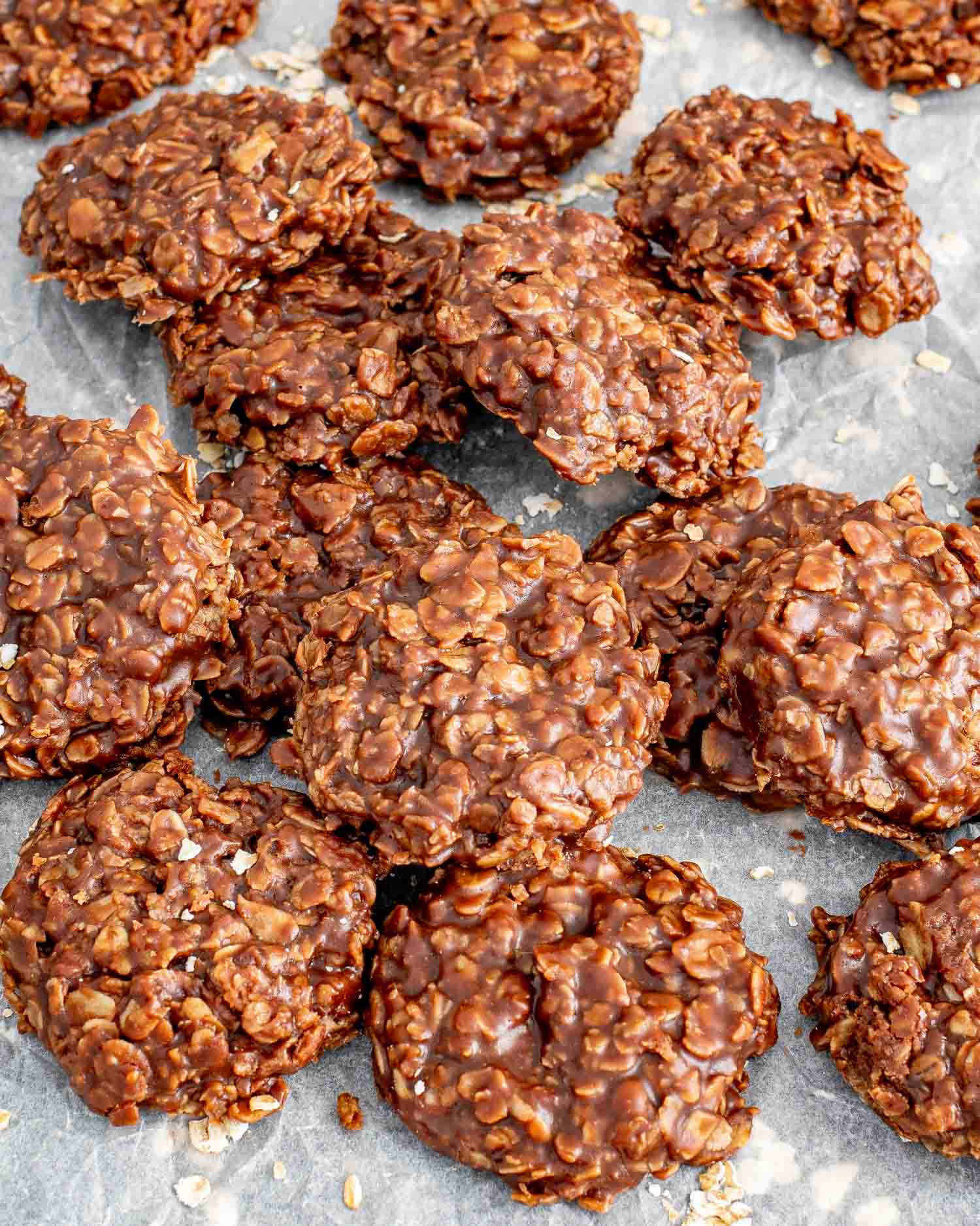 a bunch of no bake chocolate oatmeal cookies on a piece of parchment paper.