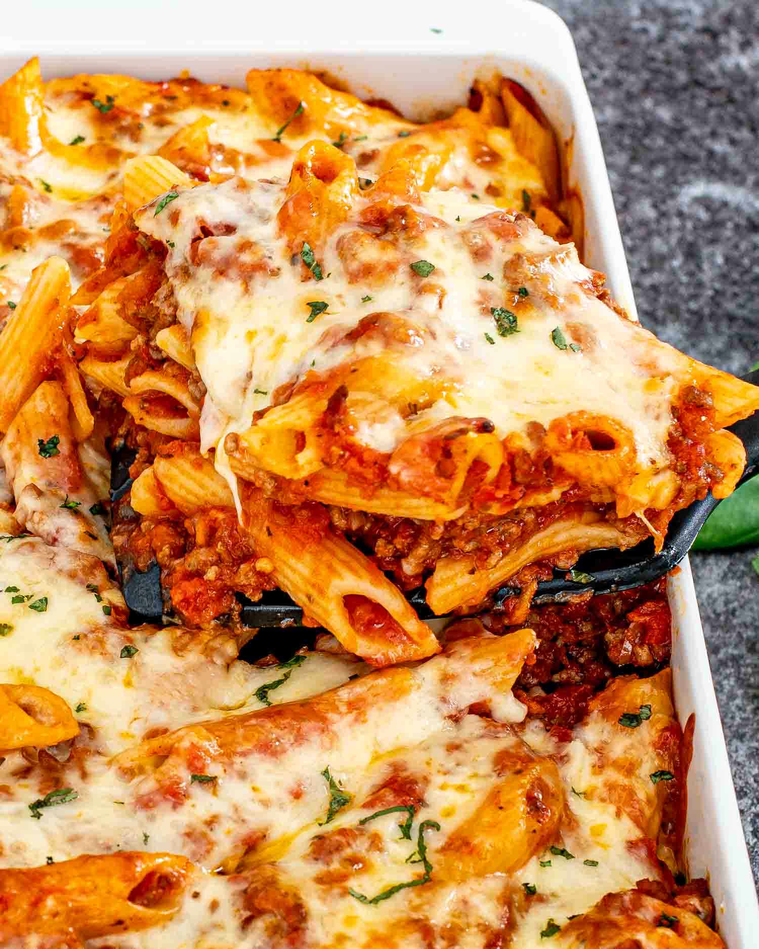 freshly baked mostaccioli in a white casserole dish.