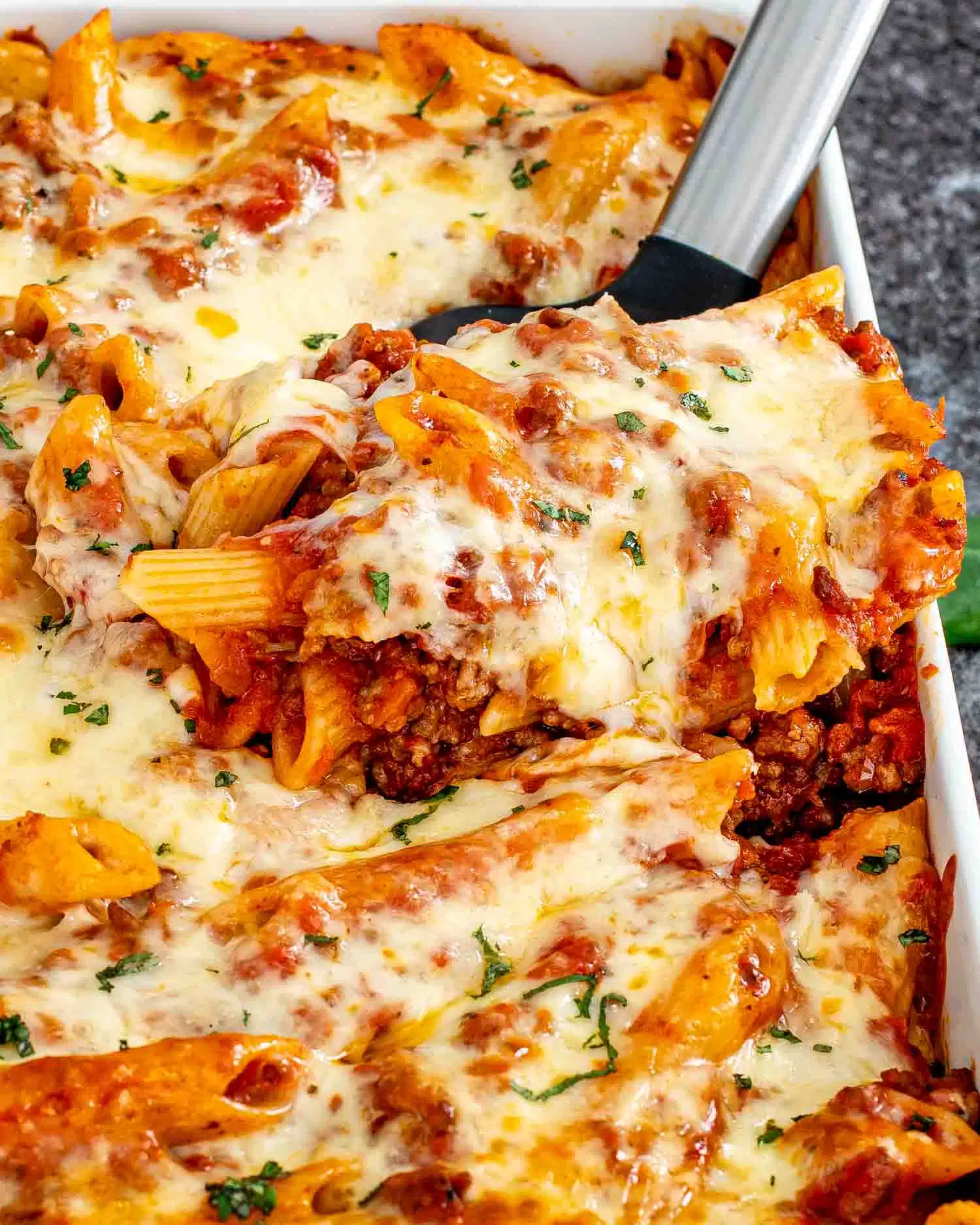 freshly baked mostaccioli in a white casserole dish.