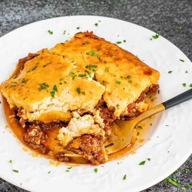 a slice of moussaka on a white plate.