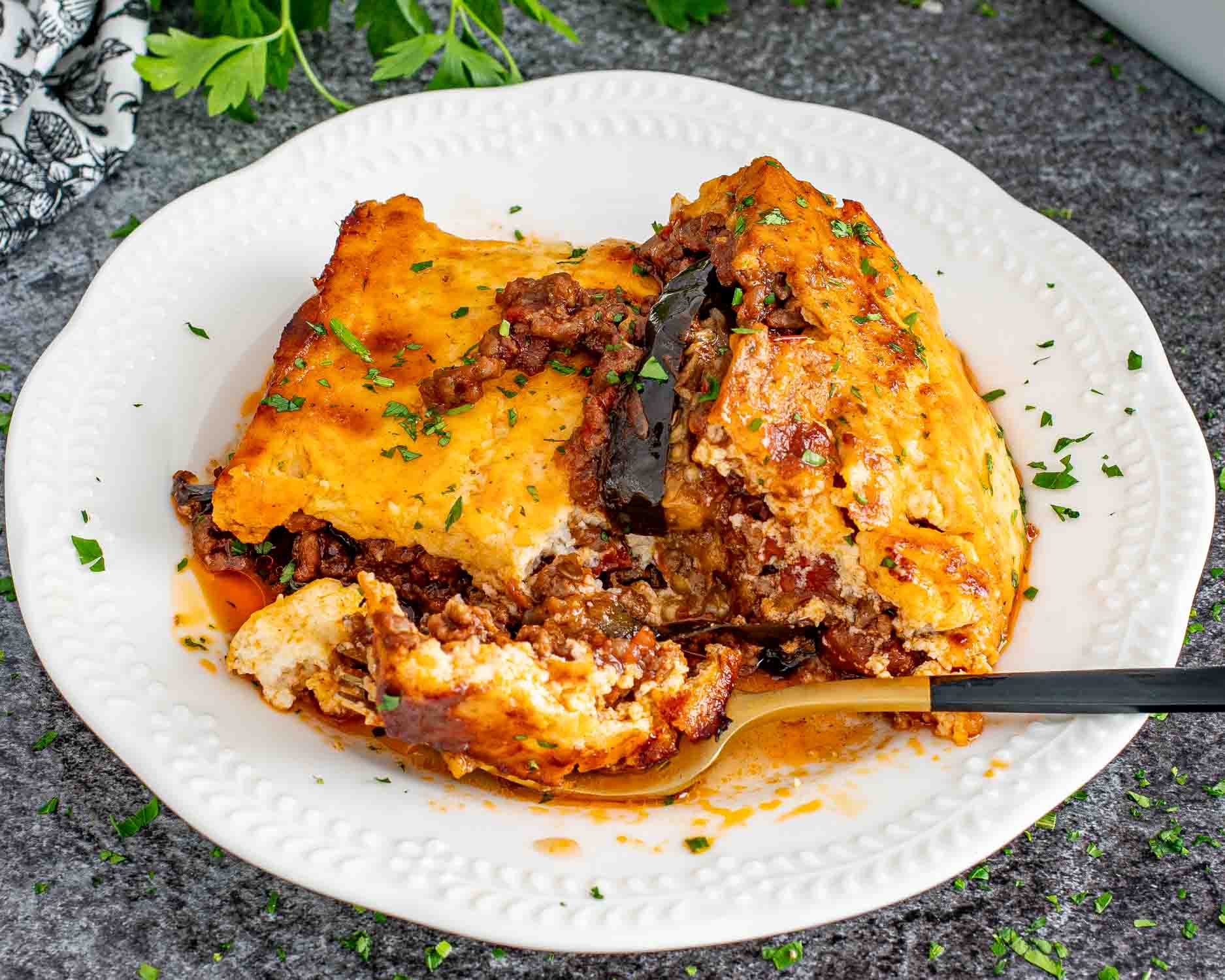 a slice of moussaka on a white plate.