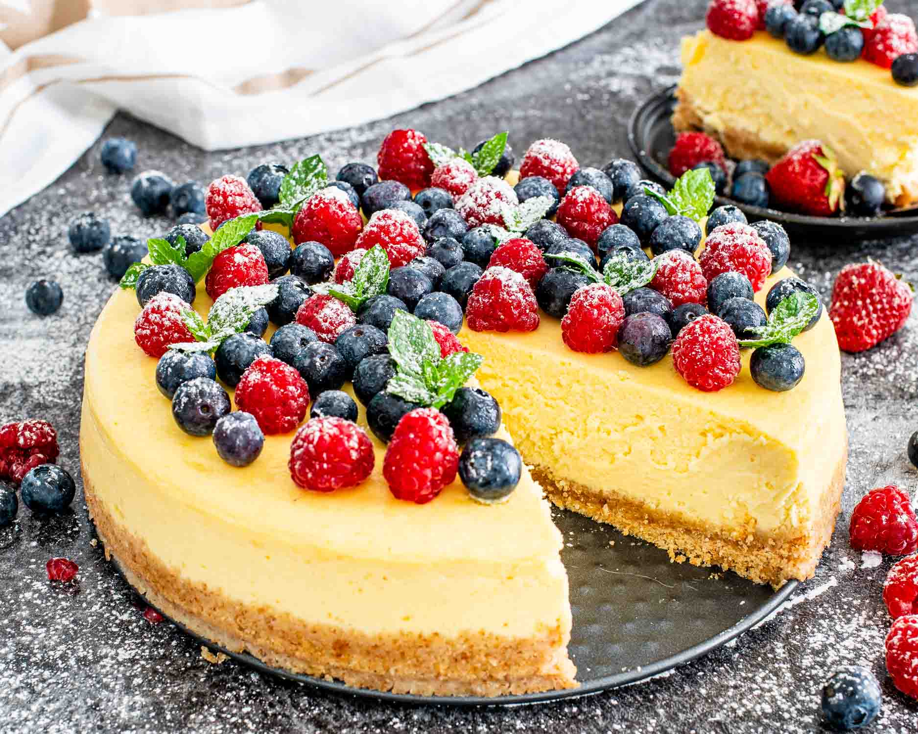 a gorgeous new york style cheesecake topped with berries.