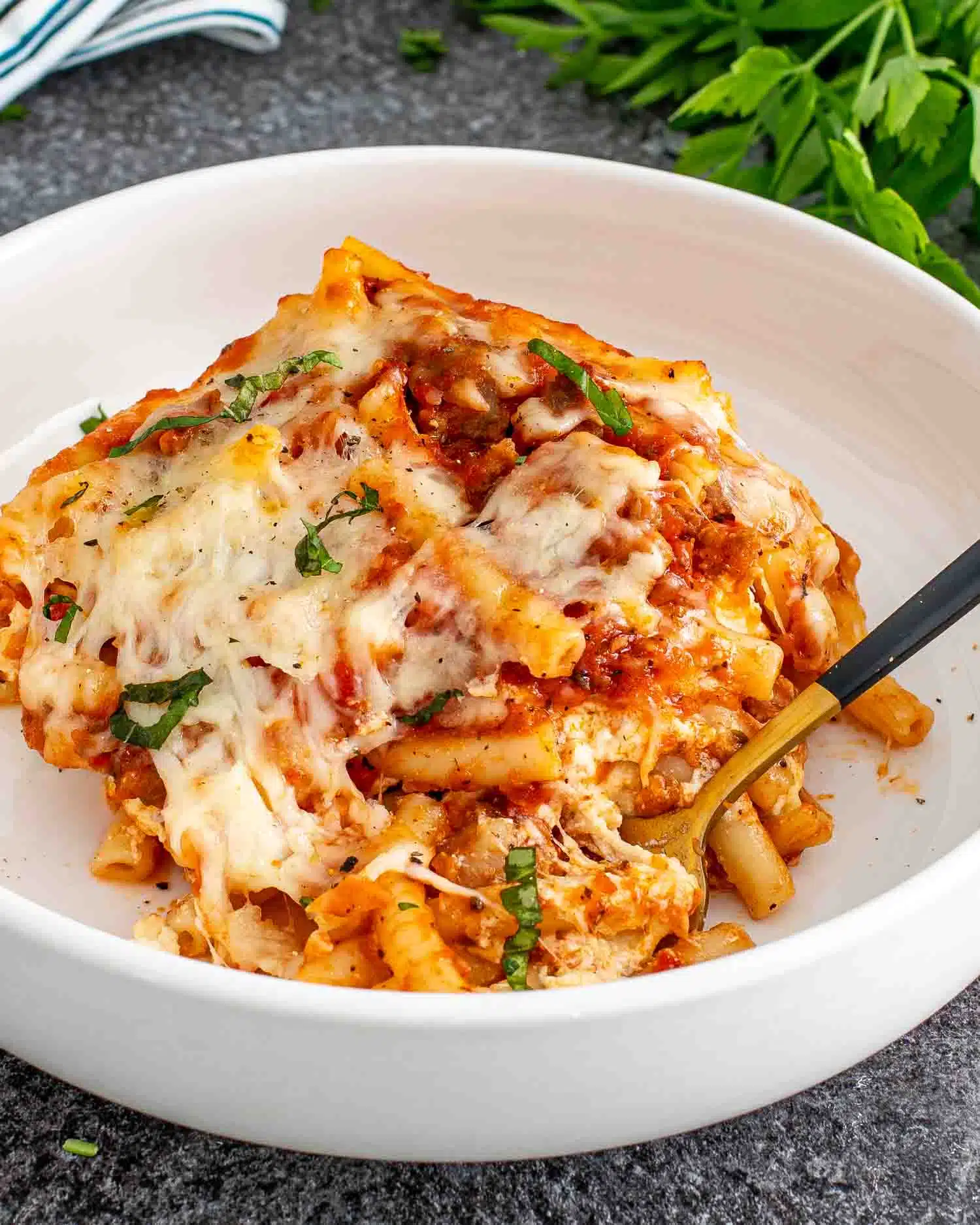 a serving of baked ziti in a white bowl.