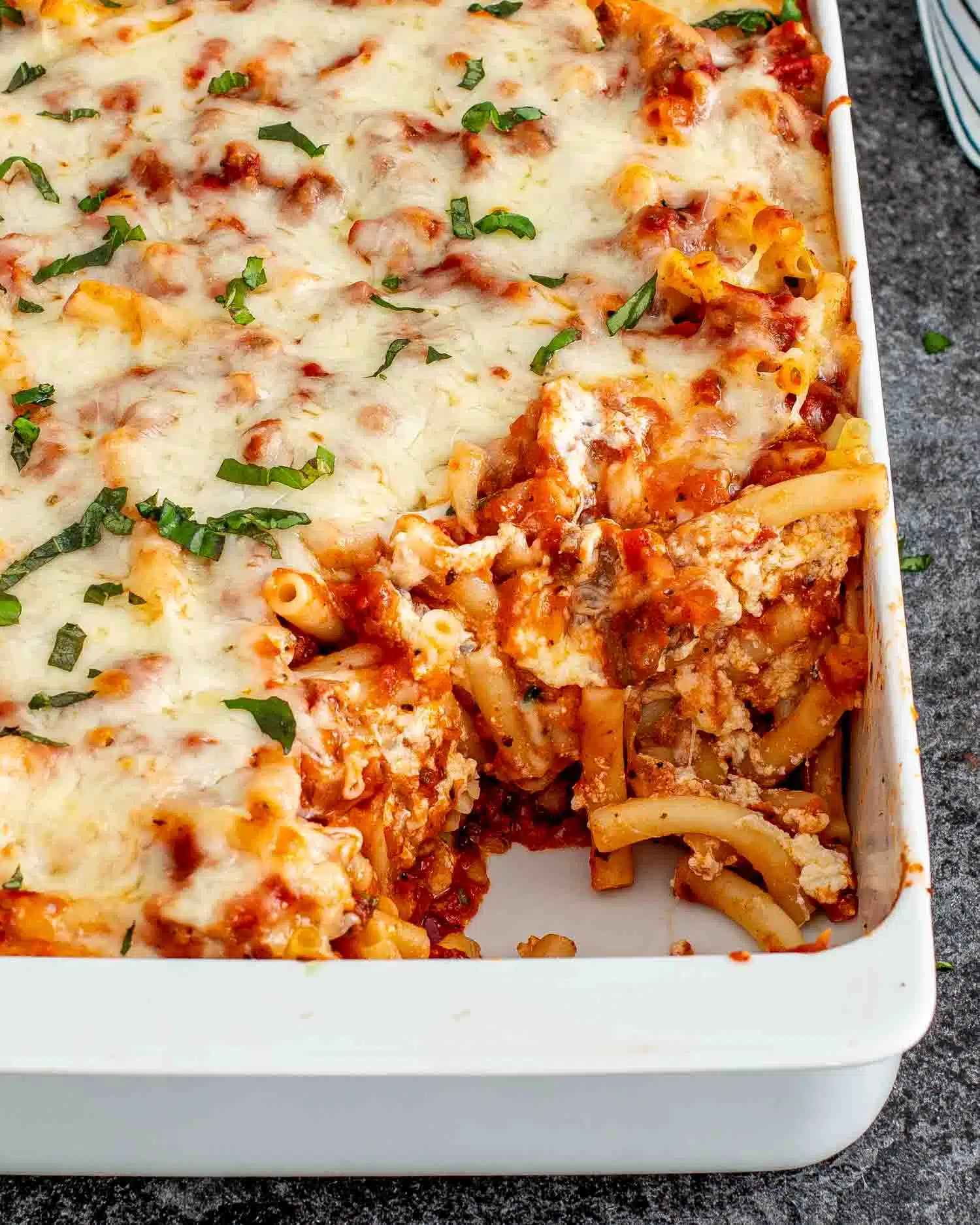 freshly made baked ziti in a white casserole dish.